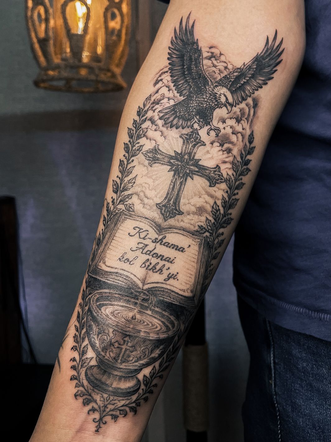 Eagle and cross permanent tattoo on a forearm