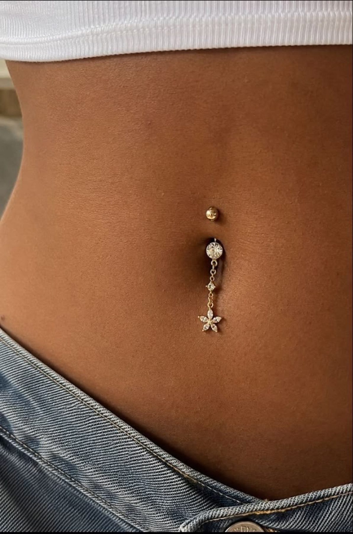 Navel piercing with a dangling jewelry design