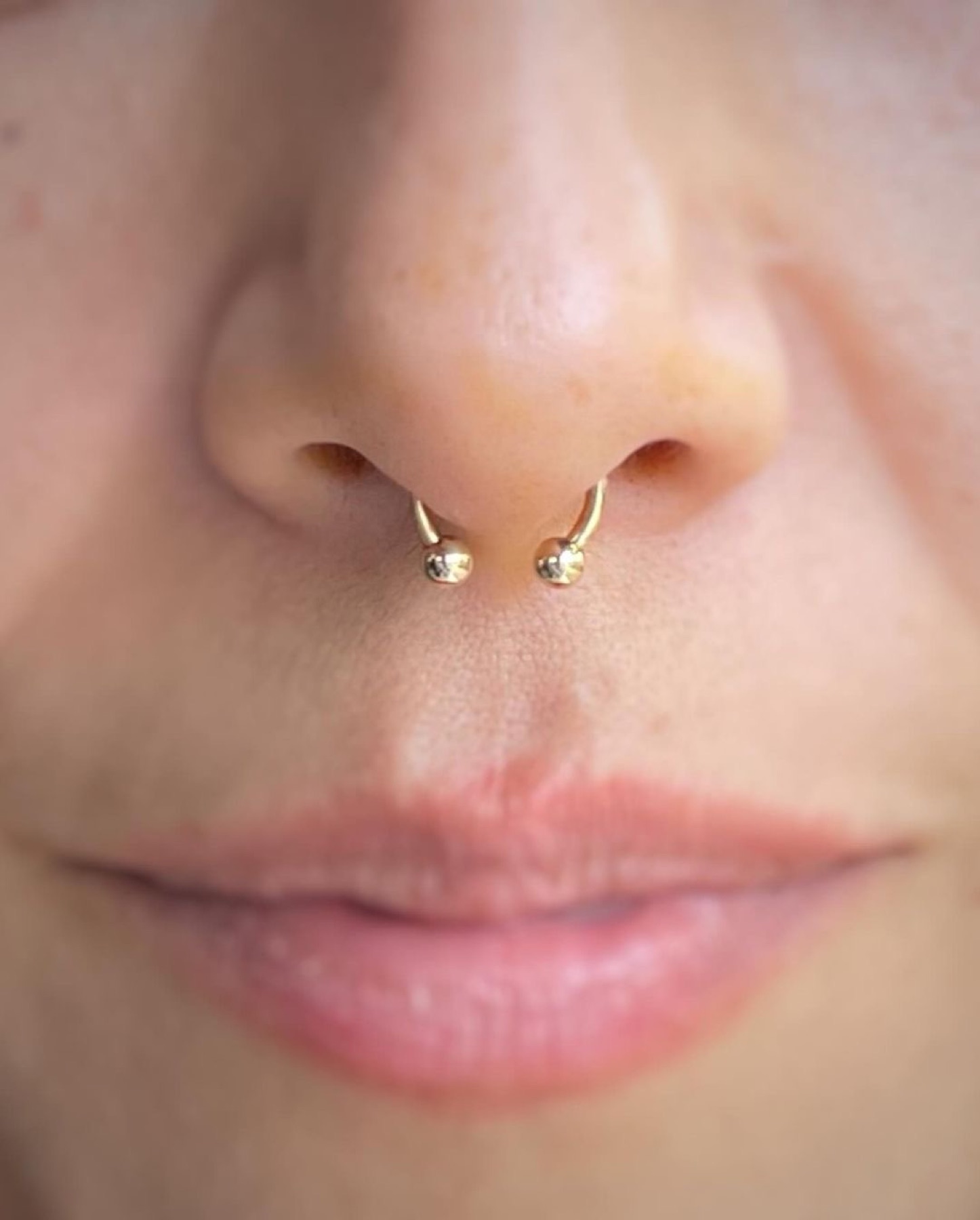 Septum piercing with gold jewelry