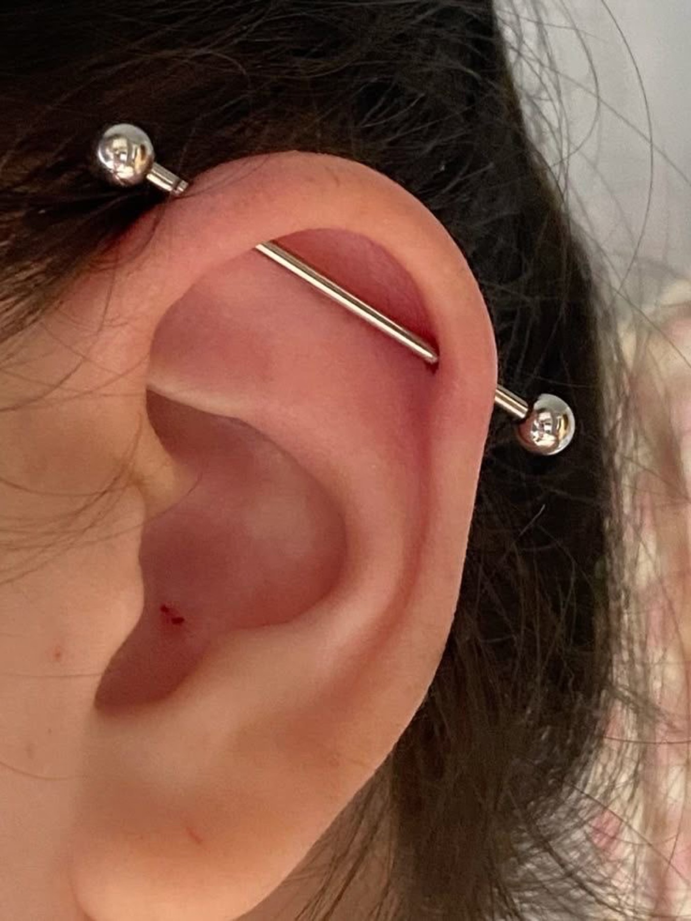 Industrial ear piercing with a barbell
