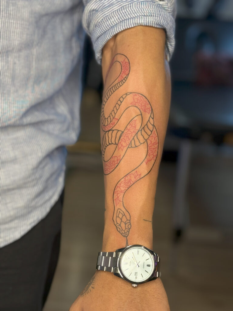Snake tattoo design on forearm with red shading – Best Tattoo Studio in Noida Sector 18